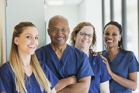 four medical workers smiling at camera